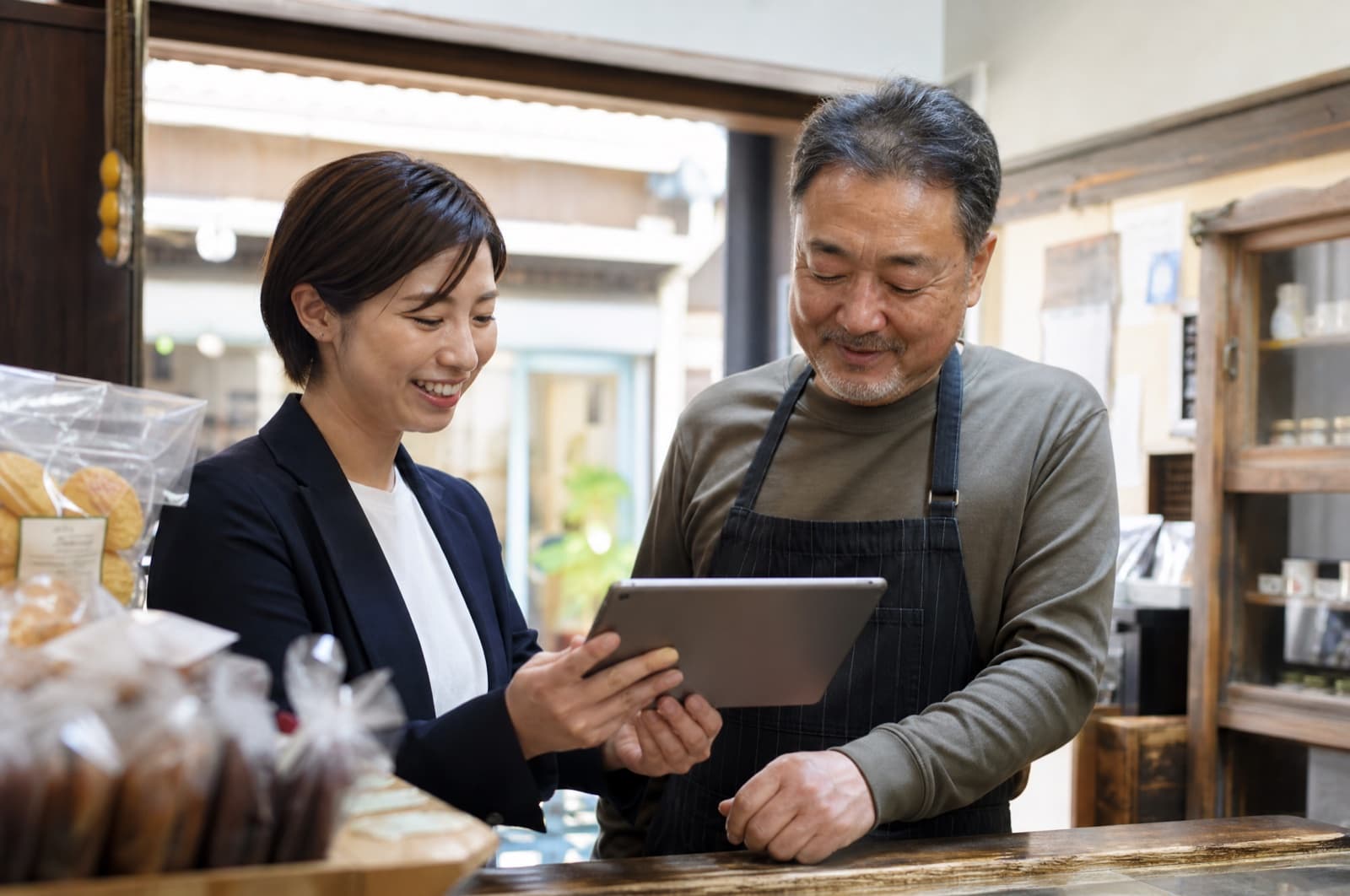 タブレットを一緒に見ながらWeb発信を相談するJKK担当者とお店の方